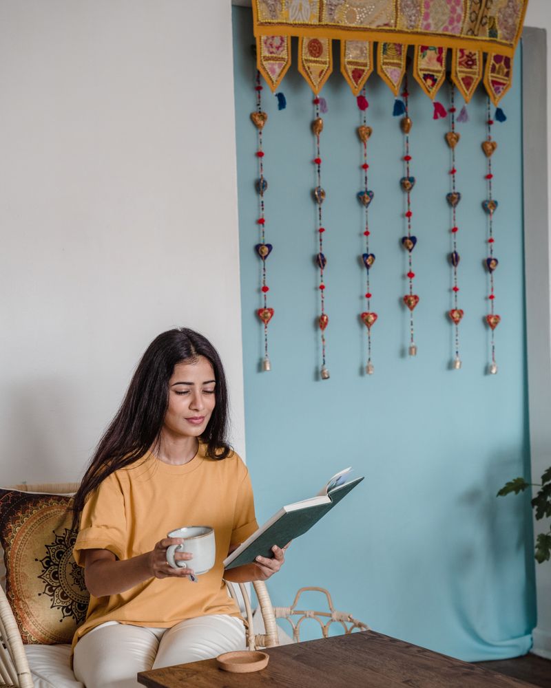 A woman in a quiet moment at home with chai and a book
